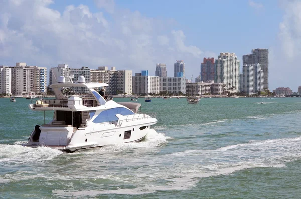 Luxury motor yacht on the florida intra-coastal waterway with Southbeach condo skyline in the backkground.
