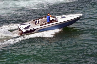 Mavi ve beyaz sürat teknesi Miami Sahili açıklarında Florida Kıyısı 'nda hız yapıyor..