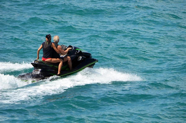 男子和女子在迈阿密海滩外的比斯开湾乘坐一架黑色喷气式滑翔机 — 图库照片