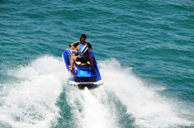 Genç bir oğlan ve kız jet ski 'ye biniyorlar..