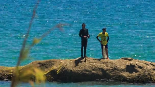 İki adam kayanın üzerinde durmak — Stok video