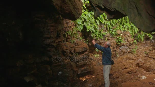 Stary człowiek fotografowania ciemności jaskini — Wideo stockowe