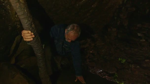 Oude man in een donkere grot met baard — Stockvideo