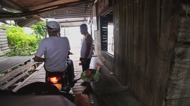 Jinetes en scooters pagan por cruzar río por puente de madera — Vídeos de Stock