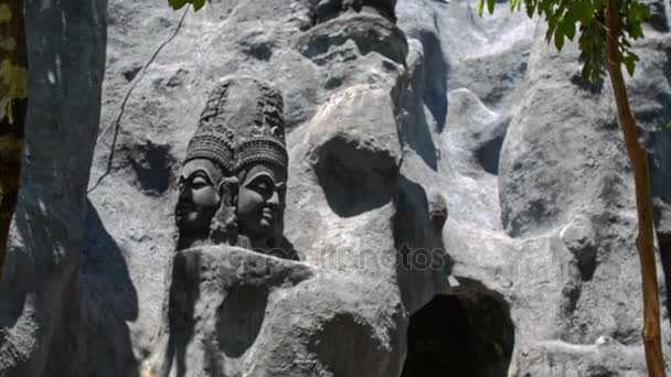 God hoofden stenen sculpturen op ruw muur — Stockvideo