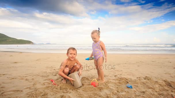 Niños jugando en la playa de arena — Vídeos de Stock