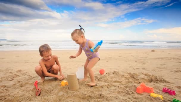 Niños jugando en la playa de arena — Vídeos de Stock