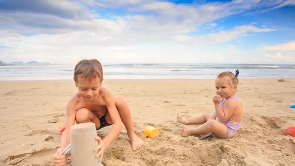 Kinder spielen am Sandstrand — Stockvideo