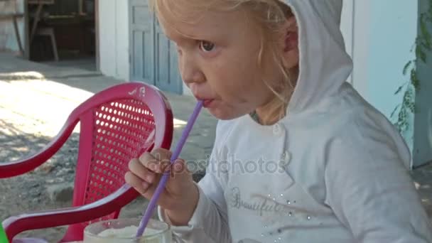 Bambina beve succo di frutta nel caffè — Video Stock