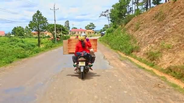 Scooter met sierkist langs een landweg — Stockvideo