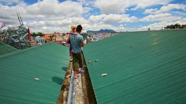 Padre con hija camina en el techo contra la ciudad — Vídeos de Stock