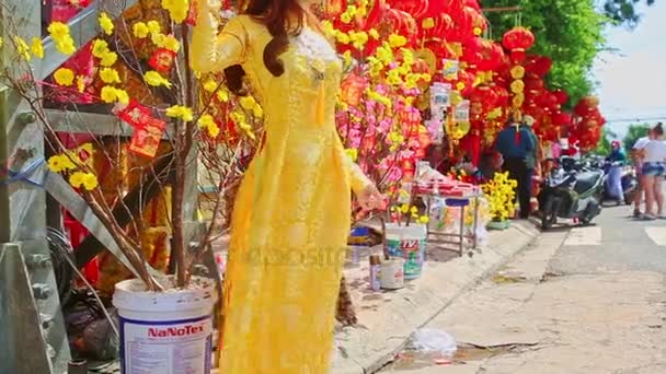 Дівчина в довгій сукні позує з квітів — стокове відео
