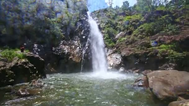Гірський водоспад тече серед скелястих схилів — стокове відео