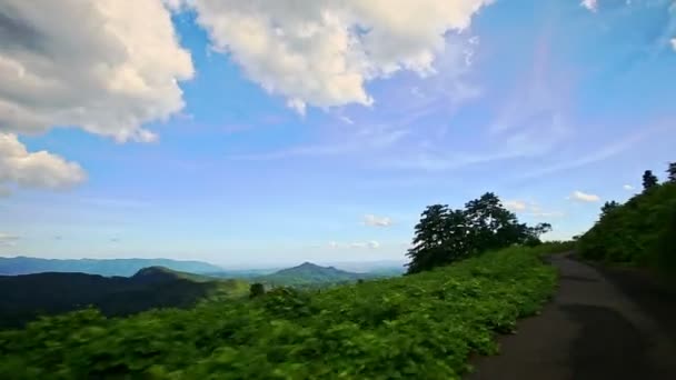 Холмистый пейзаж в высокогорье на обочине дороги — стоковое видео