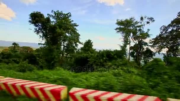 Scooter langs een landweg onder groene landschap — Stockvideo