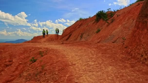 Туристи стояти на схилі пагорба грунтової дороги — стокове відео