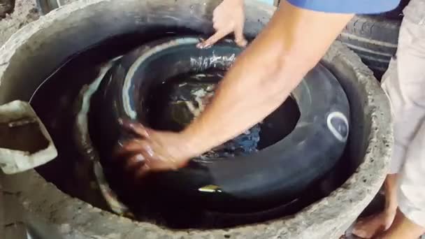Un hombre está reparando una rueda en su motocicleta — Vídeos de Stock