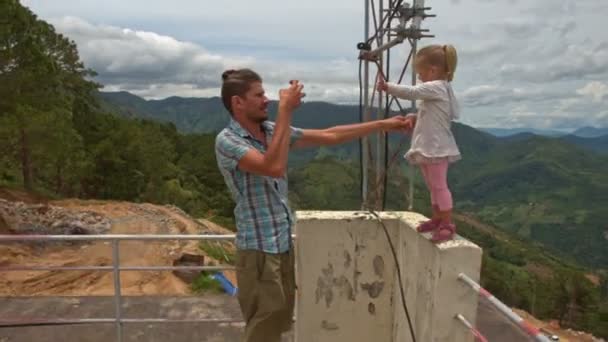 Vader neemt een foto van meisje tegen vallei — Stockvideo