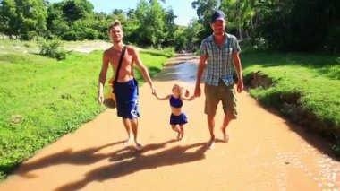 İki adam küçük kız peri dere boyunca yürüyüş ellerini tutun