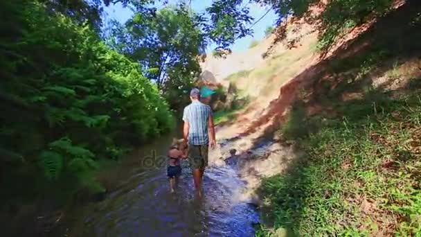 Pappa dotter promenad längs strömmen mellan skuggiga och soliga banker — Stockvideo