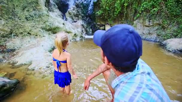 Отец и дочь стоят в потоке Посмотрите на водопад — стоковое видео