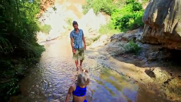 Père suit la petite fille blonde le long de Fairy Stream — Video