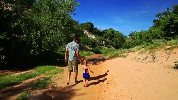 Pai e filha caminham de mãos dadas no leito do rio molhado — Vídeo de Stock