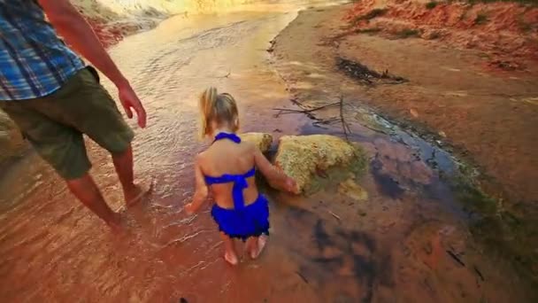 Chica descalza juega en poco profunda corriente de hadas por las rocas — Vídeo de stock