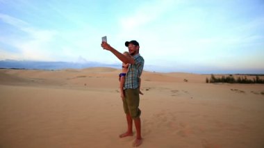 Babası tutan kız Selfie Dunes üzerinde yapar 