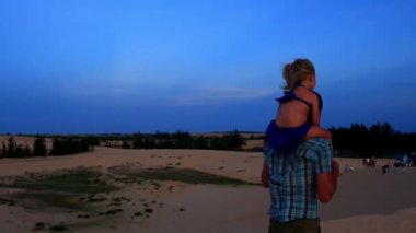 Baba ile kız Dunes omuzlarında yürür