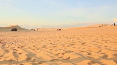 Kız yalınayak kum tepeleri üzerinde çalışır 