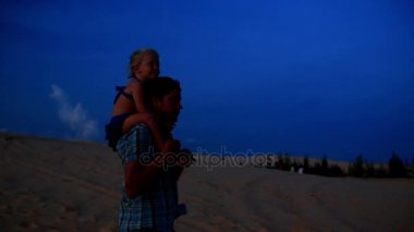 Baba kız Dunes omuzlarında üzerinde tutarak yürür