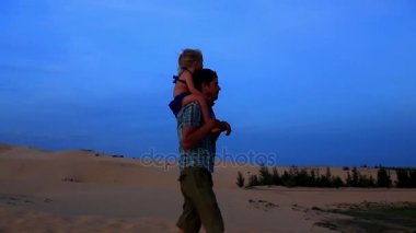 Baba ile kız Dunes omuzlarında yürür