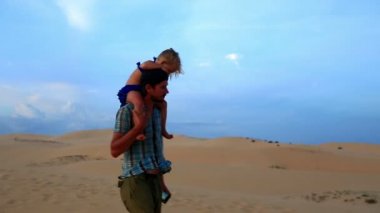 Babası yürüyor kız Dunes karşı taşır.