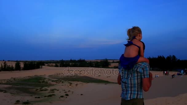 Vater geht mit Mädchen auf Schultern auf Dünen — Stockvideo