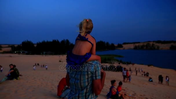 Отец держит девочку на плечах в дюнах — стоковое видео