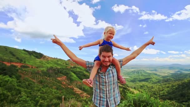 Père tient la fille sur les épaules à côté de la vallée — Video