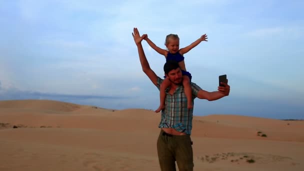 Père porte fille sur dune fait selfie — Video