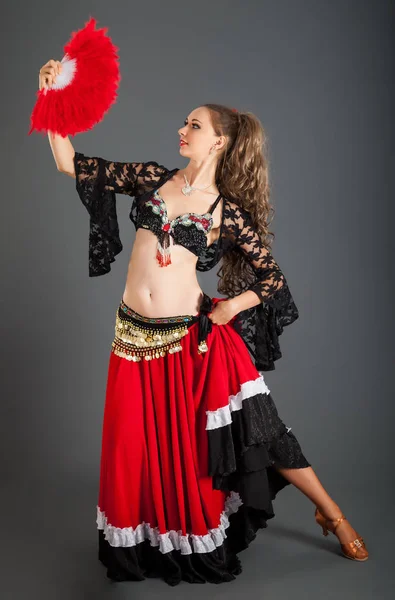 Dame im rot-schwarzen Flamenco-Kostüm mit rotem Fächer in der Hand — Stockfoto