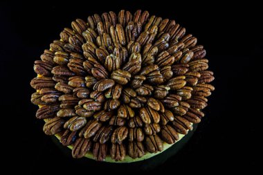 siyah ayna arka planda yukarıdan badem ile kaplı yuvarlak bisküvi kek