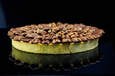 siyah ayna zemin üzerine badem ile kaplı yuvarlak bisküvi kek