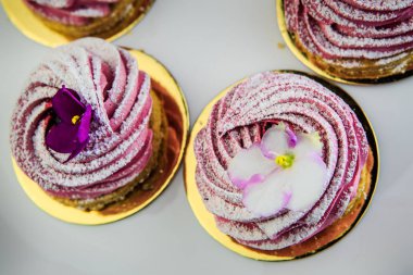 Yukarıdaki beyaz tabakta mor çiçekler closeup pembe zephyr çerezleri süslenmiş