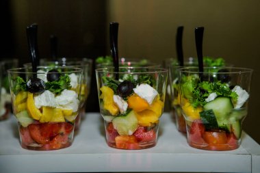 Ziyafet Servisi catering üzerinde cam üstüne Yunan salatası kırmızı domates, mozzarella peyniri ve yeşil fesleğen yaprakları