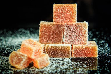 siyah ayna arka plan üzerinde şekerli portakal marmelat Piramidi closeup kaplı