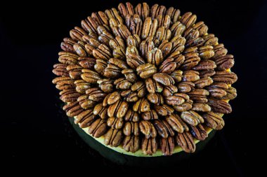 el yapımı bisküvi tart yukarıdan siyah ayna zemin üzerine badem ile kaplı