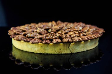 siyah ayna zemin üzerine badem ile kaplı kahverengi bisküvi tart