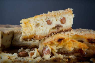 Üzümlü el yapımı cheesecake tatlı küçük parça gri arka plan karşı ahşap tablet alınarak tüm pastanın üzerinde duruyor