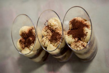Üç tiramisu tatlılar bardaklarda tablo üstten görünüm üzerinde kürek