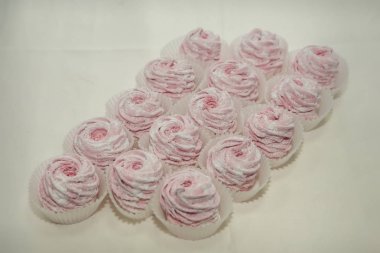 Pudra şekeri pembe beyaz arka plan üzerinde kürek zephyr tatlılar