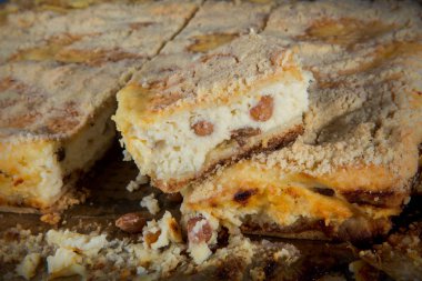 Üzümlü el yapımı peynirli kek tek küçük parça ahşap tablet üzerinde hizmet tüm pastanın üzerinde duruyor